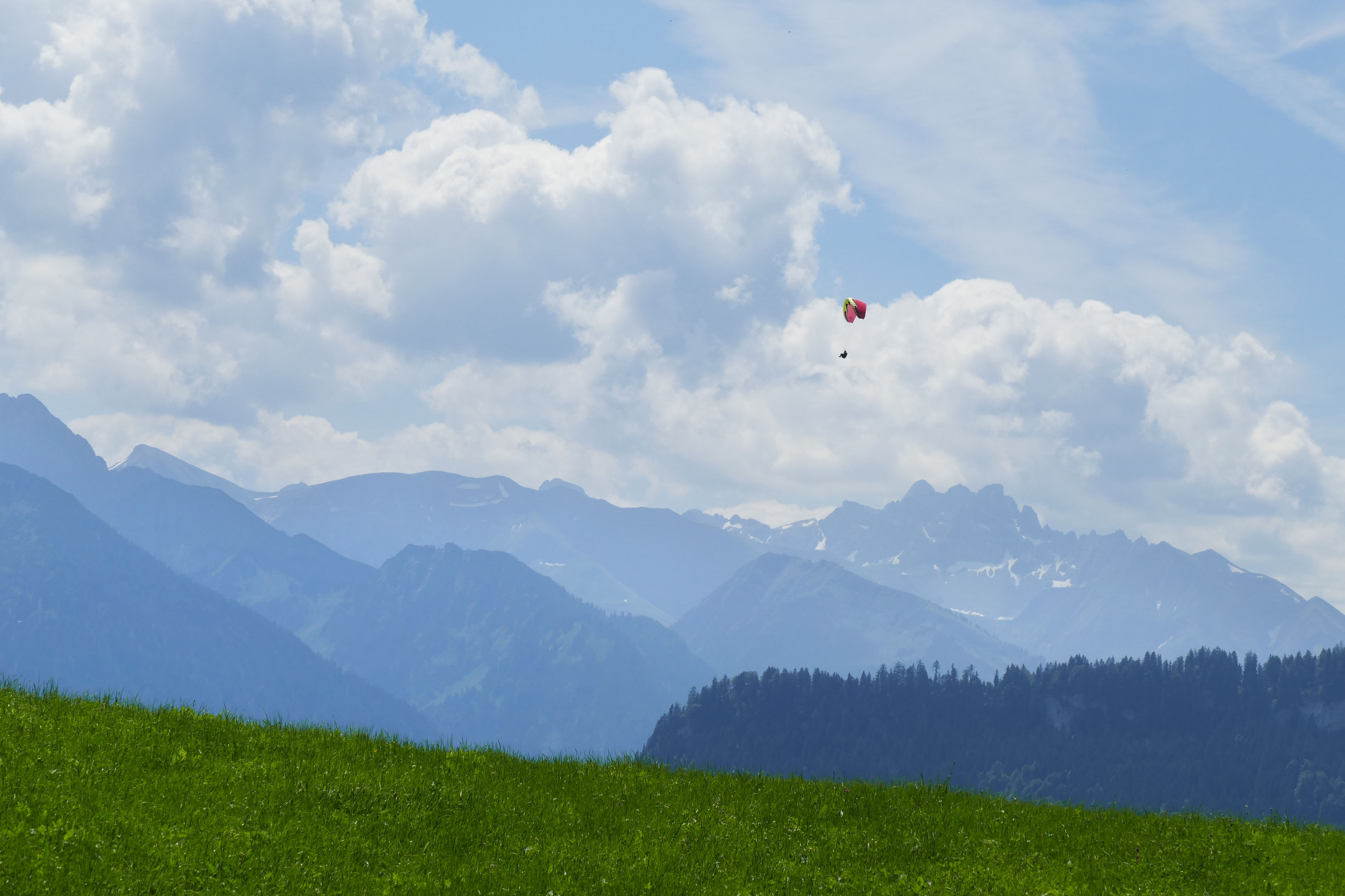 Landschaft mit Gleitschirmflieger